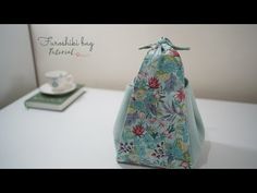 a purse sitting on top of a table next to a tea cup and saucer