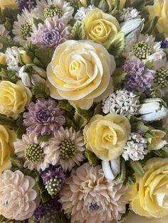 a bouquet of yellow and purple flowers sitting on top of a table