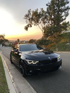 a black car is parked on the side of the road