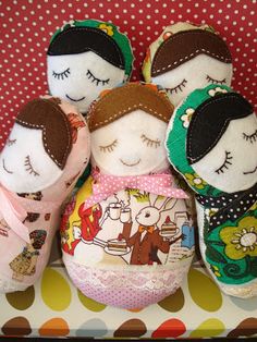 four stuffed dolls sitting on top of a table