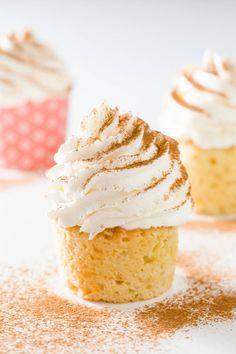 three cupcakes with white frosting and cinnamon sprinkles