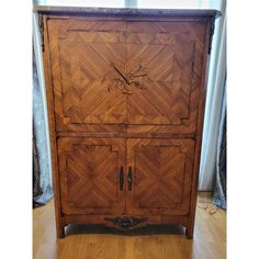 an old wooden cabinet is sitting in front of a window