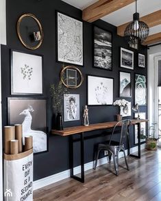 a room with black walls and pictures hanging on the wall, along with a wooden floor