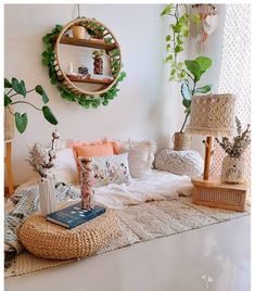 a living room filled with lots of furniture and plants on top of a rug next to a window