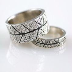 two wedding rings made out of silver leaf print, one is black and the other is white