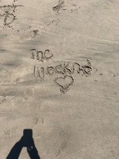 the shadow of a person's hand and footprints in the sand with words written on them