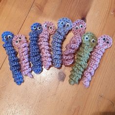 five crocheted animals sitting on top of a wooden floor next to each other