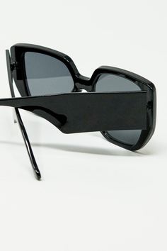 These black pin-up style sunglasses are a striking nod to 70’s Hollywood glamour, blending retro flair with a modern edge. The bold square shape, combined with a geometric cat-eye design, creates a captivating look reminiscent of vintage pin-up icons. The sharp, angular lines of the frame add a contemporary twist to this classic style, making them perfect for anyone looking to channel their inner starlet.  Crafted from 100% polycarbonate, these sunglasses offer both durability and lightweight comfort, ensuring they can be worn effortlessly throughout the day. The high-gloss black finish enhances their timeless appeal, making them a chic accessory for any occasion.  The model is wearing size U, designed to offer a universally flattering fit, making these sunglasses a versatile addition to a Square Polarized Sunglasses For Parties, Chic Square Sunglasses For Party, Modern Rectangular Sunglasses For Party, Black Square Sunglasses For Parties, Black Square Sunglasses For Party, Sleek Square Frame Sunglasses For Party, Chic Black Square Sunglasses, Retro Black Cat Eye Sunglasses With Tinted Lenses, Square Frame Tinted Cat Eye Sunglasses For Party