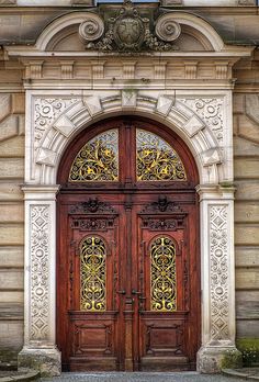 an ornate wooden door in front of a stone building