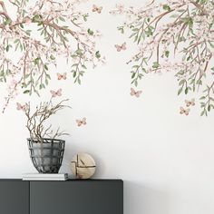 a vase filled with flowers next to a wall mural