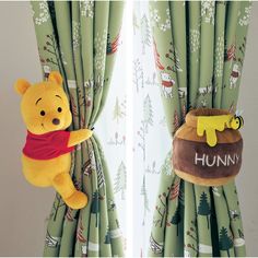 a winnie the pooh stuffed animal hanging from curtains