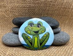 a painted frog sitting on top of some rocks