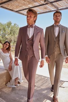 two men in tuxedos are walking down the street with one man wearing a white shirt and tie