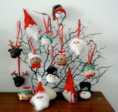 a group of christmas ornaments sitting on top of a wooden table next to a tree