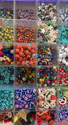 many different types of beads are arranged in bins