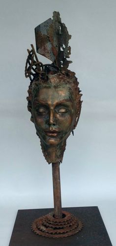 a metal sculpture with a woman's head on top of it