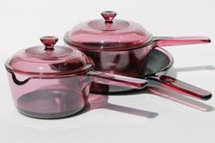 two pink pots and pans on a white surface