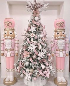 a pink and white christmas tree with nutcrackers