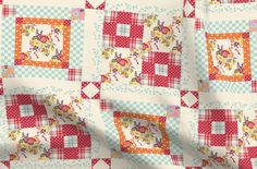 a close up view of a quilt with squares and flowers on it's sides