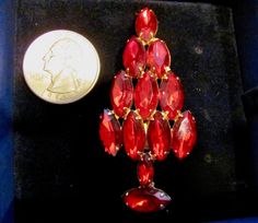 "SALE Vintage ATTRUIA Style Red Marquise Rhinestone Christmas Holiday Brooch Pin In Gold Tone Faceted Swarovski Crystal Vintage Collectible Pins Retro High End Quality Made Un-Signed ATTRUIA Red Marquise Rhinestone Christmas Tree Pin From the 60's. Picture #5 shows an Attruia Book Piece Pin. This pin is not a reproduction, it is a collectible retro brooch from the 60's. The brooch came to me in a velvet lines SWAROVSKI box, which will be included with the sale of the pin. This pin features eleve Vintage Red Marquise Cut Jewelry, Vintage Red Marquise-cut Jewelry, Vintage Red Brooches For Festive Occasion, Vintage Rhinstone Christmas Jewelry, Holiday Red Brooch Jewelry, Christmas Bling, Holiday Costumes, Book Pieces, Christmas Pins