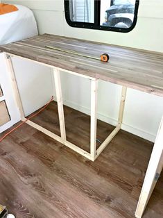 a desk made out of wooden planks in front of a window