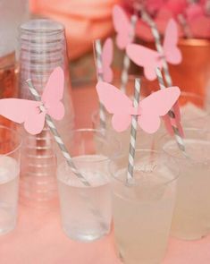 pink butterfly straws in cups with paper straws sticking out of the top one