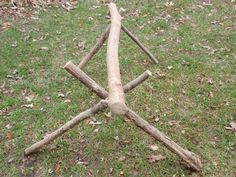 a wooden cross made out of branches in the grass