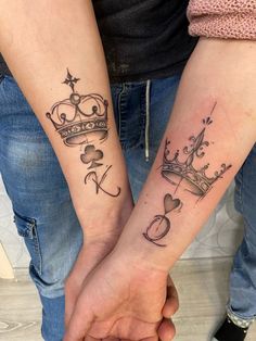 two people holding hands with tattoos on their arms