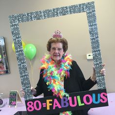 an older woman wearing a tiara and holding a sign that says 80 - fabulous