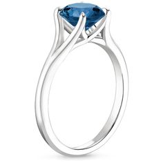 an oval blue topazte ring with two curved sides, set in 18k white gold