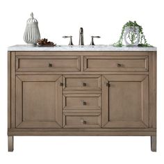 a bathroom vanity with two sinks and a vase on the counter top next to it