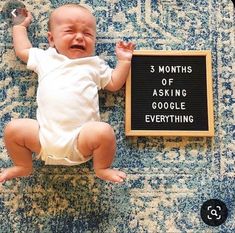 a baby sitting on the floor next to a sign that says 3 months of asking google everything