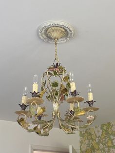 a chandelier hanging from the ceiling in a room with floral wallpaper on the walls