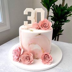 a cake decorated with pink flowers and the number twenty