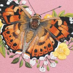 an orange and black butterfly sitting on top of a pink surface next to yellow flowers