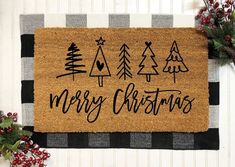 a merry christmas door mat with trees on it