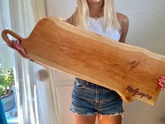 a woman holding a large wooden board in her hands