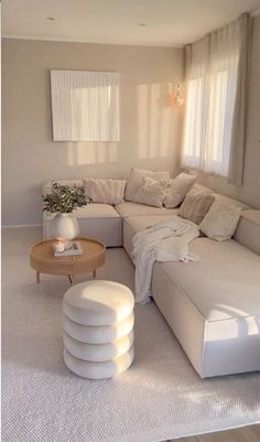 a living room filled with white furniture and lots of pillows on top of the couch