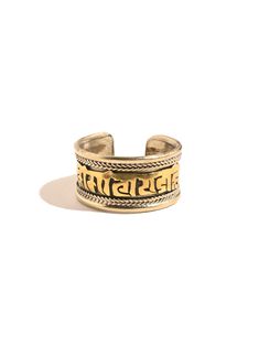 This adjustable ring is hand crafted by local artists of Nepal. It features the well known and oft chanted Tibetan holy mantra Om Mani Padme Hum artfully carved around the band, and a delicate rope like design decorating both sides. The brass ring can be gently pressed together to adjust to whichever finger on which you choose to wear it. Attractive and adjustable. Band measures almost 1/2 inch wide. Handcrafted in Nepal. Gold Adjustable Engraved Spiritual Ring, Adjustable Gold Engraved Spiritual Ring, Symbolic Adjustable Promise Jewelry, Spiritual Promise Engraved Ring, Spiritual Engraved Promise Ring, Spiritual Brass Engraved Ring, Adjustable Gold Engraved Ring, Gold Engraved Adjustable Ring, Spiritual Adjustable Engraved Brass Ring