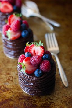 chocolate dessert with strawberries, raspberries and blueberries in it on a table