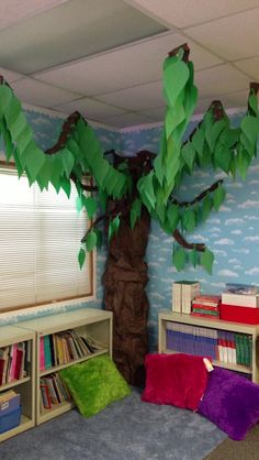 a room with a tree and bookshelves in it