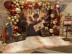 a table topped with lots of balloons and harry potter decorations