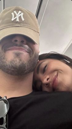 a man and woman hugging each other while on a subway train with their eyes closed