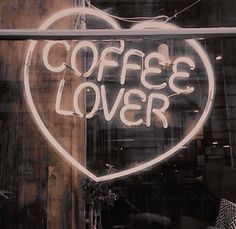 a sign that says coffee lover on the side of a store front window with graffiti