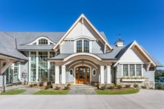 a large white house with lots of windows on it's front porch and driveway