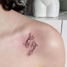 a woman with a tattoo on her shoulder has a fish in it's stomach