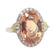 A magnificent 18k Rose and White Gold Natural Imperial Topaz and Diamond Ring. The center stone is a rare peach color natural Imperial Topaz 5.97 carat measuring 13.96x9.44x5.28mm. The center stone is flanked with a matching pair of GIA certified Natural Fancy Yellow heart shapes weighing 0.33 carats (4.3x4.65x2.71mm, VS2 clarity) and 0.31 carats (4.28x4.66x2.65mm, SI1 clarity). Also set are 20 natural round brilliant colorless diamonds weighing 0.30 carats. Total weight of ring is 6 grams, size 5.75… and total gemstone weight is 6.91 carats. Topaz And Diamond Ring, Jewelry Real, Yellow Rings, Imperial Topaz, Yellow Heart, Colorless Diamond, Peach Color, Cocktail Rings, Round Brilliant