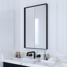 a bathroom sink with a mirror above it and a black faucet in front of it