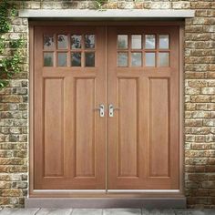 two wooden doors are shown in front of a brick wall