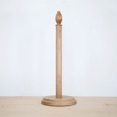 a wooden pole on a table with a white wall in the backgrounnd